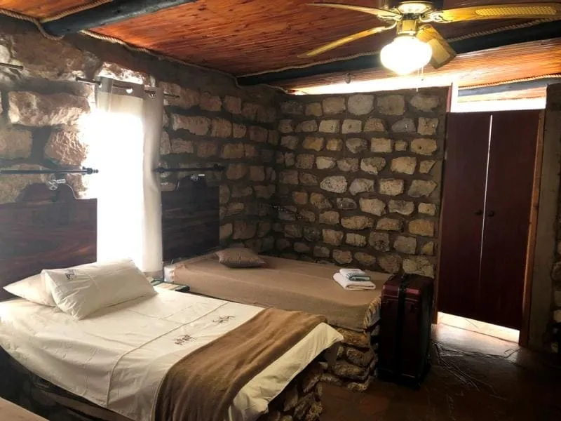 Zona de bar interior, con selección de bebidas y un ambiente rústico que refleja el carácter africano del lodge.